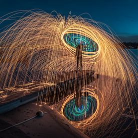 Lightpainting - Spinning burning steel wool on a riser above the water by Jolanda Aalbers