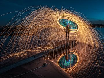 Lightpainting - Spinning burning steel wool on a riser above the water