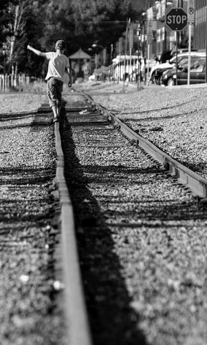 Little boy walking over a train track