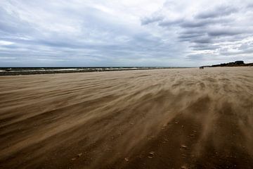 Opwaaiende zandkorrels op het strand van Stefan Zwijsen