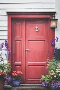 Porte rouge avec des fleurs sur Joost Lagerweij