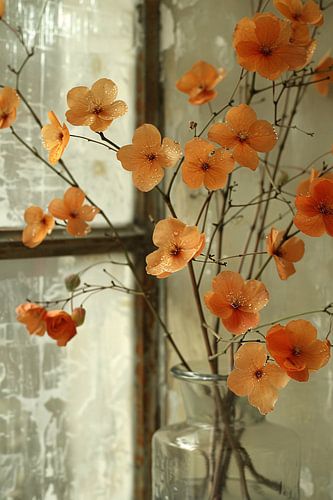 Oranje bloesems in glazen vaas