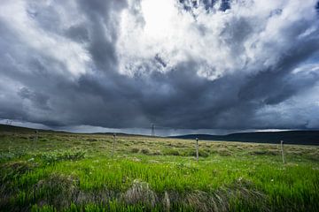 IJsland - Donkere regenwolken met onweer over groene weiden van adventure-photos