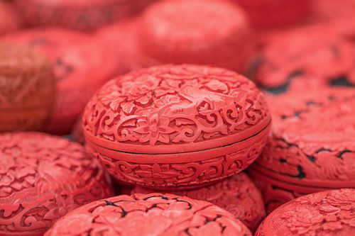 Chinese gegraveerde eivormige rode dozen op een markt