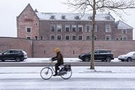 Schloss Woerden mit Radfahrer im Vordergrund im Schnee. von John Verbruggen Miniaturansicht