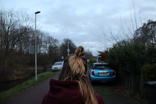 Meisje met knotje, lopend op het fietspad