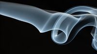 16x9 landscape image of grey white smoke on a black background