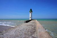 White lighthouse on a stone pier in the sea