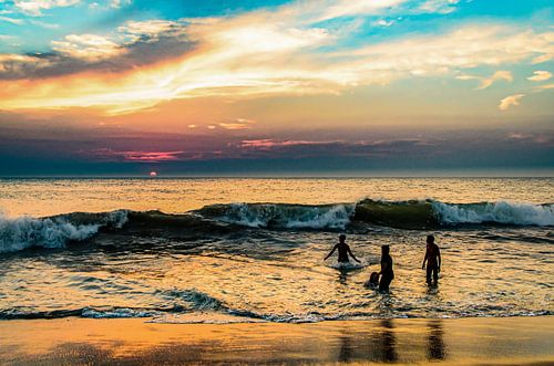 Bathing family on the beach at sunset in Sri Lanka
