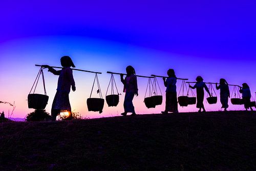 LPH 71311840 Silhouet van mensen die manden dragen bij zonsondergang, Myanmar, Burma
