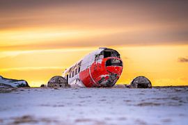 Wrack einer DC-3 in einer verschneiten Landschaft bei Sonnenuntergang, Eyvindarholt, Island von René Wiegmink