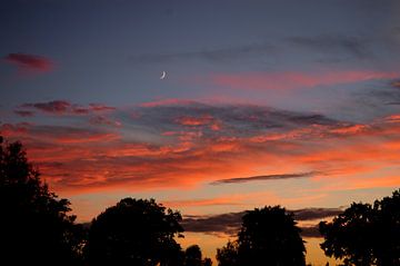 Zonsondergang met Maan en oranje wolken van Corinne Welp