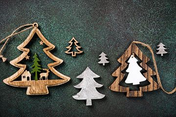 Wooden Christmas trees on green background by Iryna Melnyk