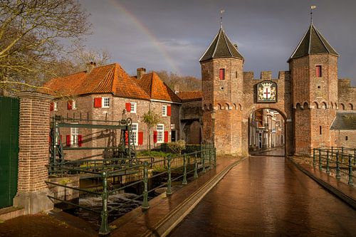 Een regenboog boven de Koppelpoort van Amersfoort in de avond.