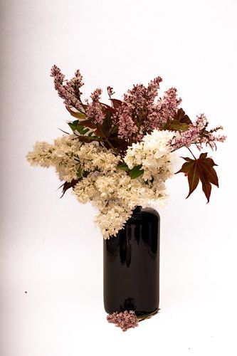 bosje roze en witte seringen in blauwe vaas