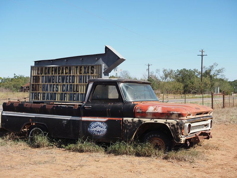 Roestige pickup truck als wegwijzer naar muzikale stad in Texas van Atelier Liesjes