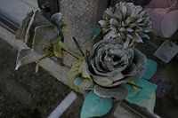 Verwelkte Seidenblumen auf einem Friedhof