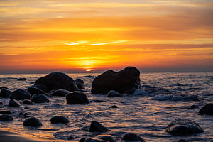Sonnenuntergang am Strand mit Großen Felsen im Wasser an der Ostsee auf Rügen