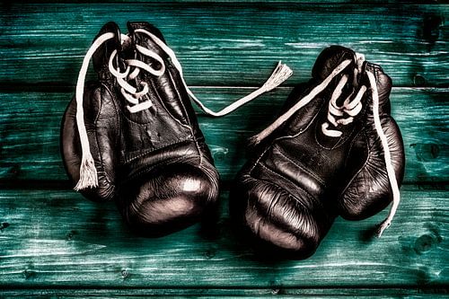 old boxing gloves on green wooden background by Jürgen Wiesler