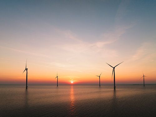 Windturbines in een offshore windpark tijdens zonsondergang