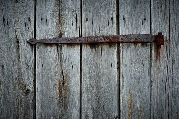 Old rusty hinge on a weathered wooden shed by Jenco van Zalk