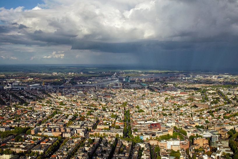 Een regenbui hangt boven de grachtengordel van Amsterdam van Marco van Middelkoop