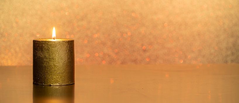 Goldene Kerze mit warmer Flamme von Alexander Baumann