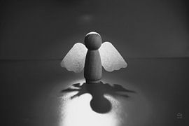 Ein Engel in dunkler Umgebung. Gebrochene Flügel in den Schatten.