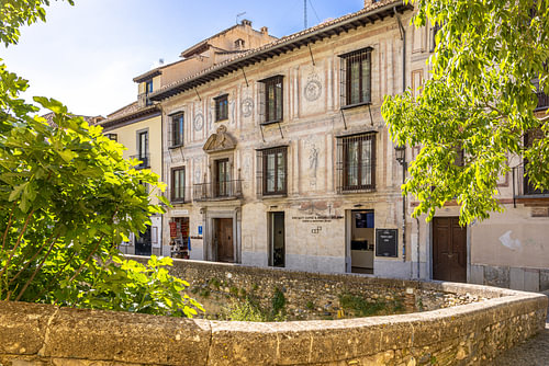 Façade Renaissance peinte derrière un mur de pierre en Andalousie