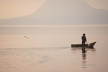 Man in canoe on lake with sunrise by Diana Stubbe