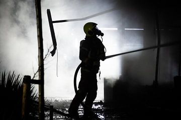 Brandweerman hard aan het werk van Martijn de Bruijn