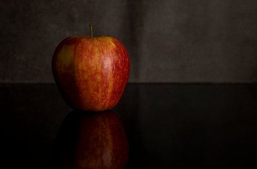 One red apple isolated on black acrylic sheet with reflection