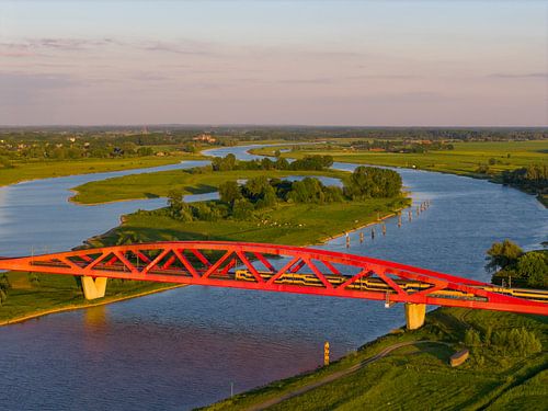 Treinbrug in een kleurrijke zonsondergang over de IJssel
