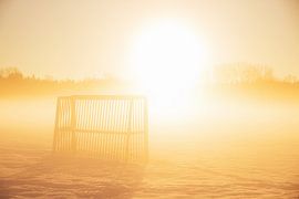Soccer goal outside on a snowy field in the yellow morning s by SusaZoom