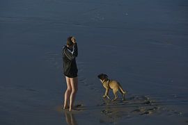 Man with dog on the beach by Taco de Jong