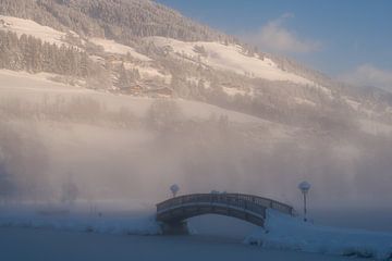 Houten brug op een mistige winterochtend met een bergpanorama van chamois huntress