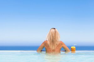 Vrouw  geniet van een drankje in het zwembad van BeeldigBeeld Food & Lifestyle