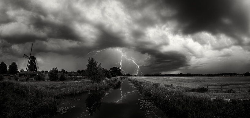 Rollende Wolken und Blitze bei der Mühle de Zwaan Vinkel in schwarz-weiß von Cynthia Verbruggen