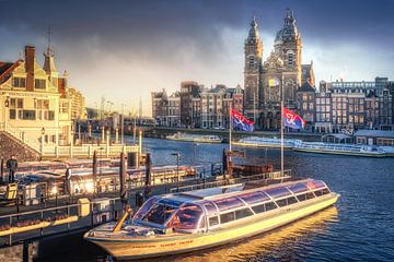 The saint nicolas baselisk in the sun with boat in the foreground and clouds in Amsterdam oosterdok