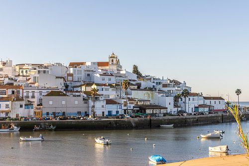 Zandstrand in de ochtend met uitzicht op het historische centrum van Ferragudo, Portimão, Algarve, Portugal