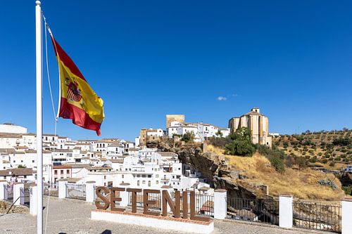 Panorama of skyline van een historische oude stad met veel witte huizen. De Spaanse vlag in Setenil de las Bodegas, Cádiz, Andalusië, Spanje.