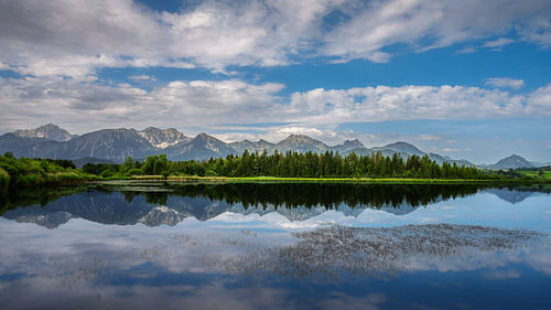 De Hopfensee met de Allgäuer Alpen en een heldere weerspiegeling
