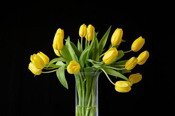 Sstilleven gele tulpen in kristallen vaas met donkere achtergrond. van Janny Beimers
