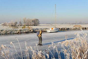 Paysage d'hiver avec patineur sur Merijn van der Vliet