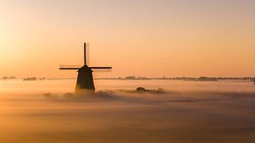 Misty sunrise with a classic Dutch windmill in a warm landscape by mitevisuals