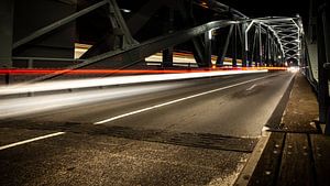 Industrielle Eisenbrücke mit beweglichem Auto beleuchtet nachts