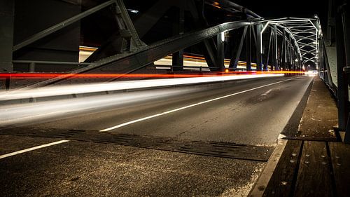 Industrial iron bridge with moving car lights at night