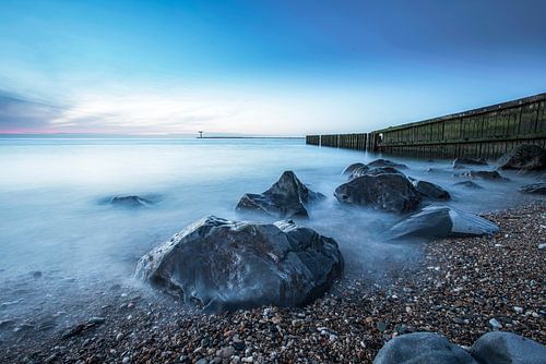 Zee aanzicht met stenen en pier