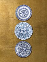 Verzameling Delfts blauwe borden op gouden achtergrond, Rijksmuseum