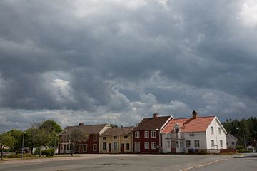 Donker lucht boven huisjes in dorp in zuid Zweden van Joost Adriaanse